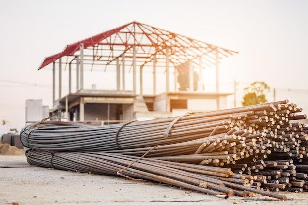 steel rebar for reinforcement concrete at construction site with house under construction background premium photo
